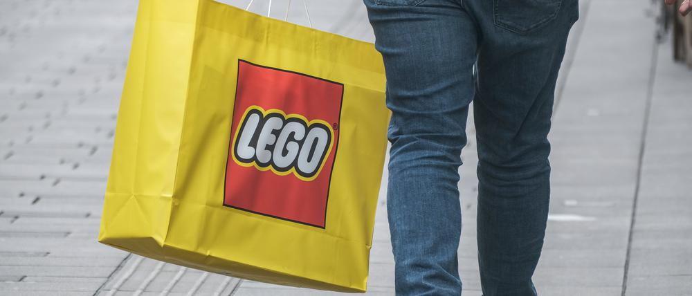 Eine Person mit einer Tasche mit dem Aufdruck „Lego“.