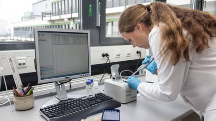Eine junge Biologin beim Pipettieren.