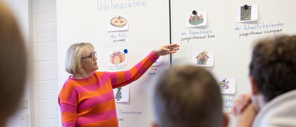 Die Lehrerin Hilde Uffelmann spricht beim Unterricht in einer Sprachlernklasse mit ukrainischen Schülern über Weihnachtsbräuche.