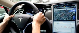 Ein Mann sitzt in einem Tesla Model S am Lenkrad. (Symbolbild
