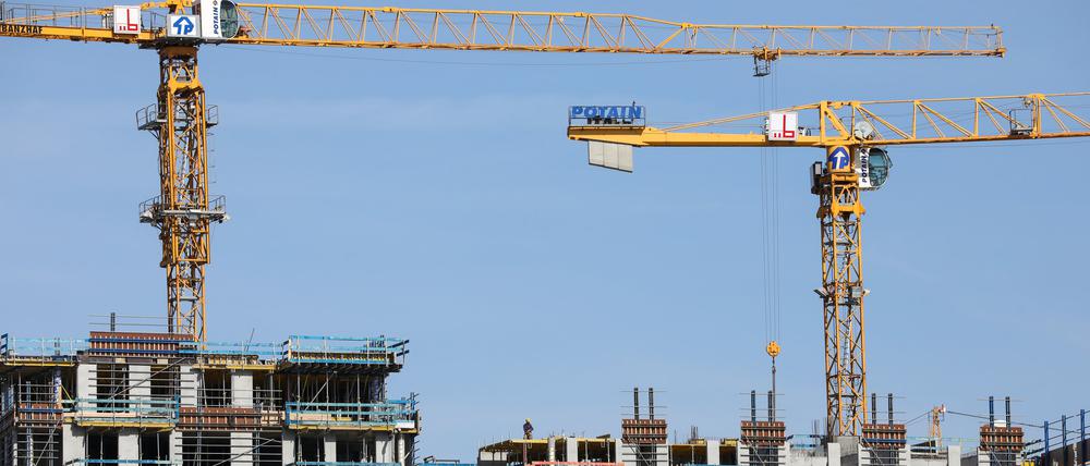 Kräne stehen auf einer Baustelle für mehrstöckige Wohnhäuser. 