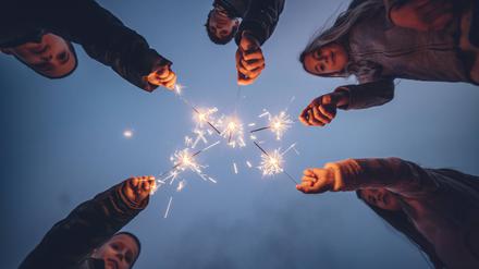 Five children holding sprklers against evening sky model released Symbolfoto OCMF01086