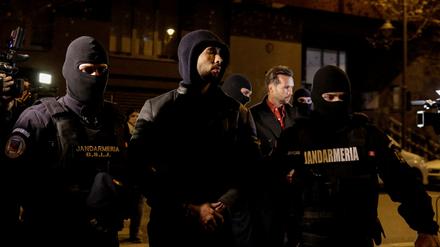 Andrew Tate und Tristan Tate werden von Polizeibeamten vor dem Sitz der Direktion für die Untersuchung von organisierter Kriminalität und Terrorismus in Bukarest (DIICOT) eskortiert.