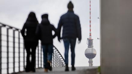 Passanten gehen vor dem Berliner Fernsehturm über den Marie-Elisabeth-Lüders-Steg.