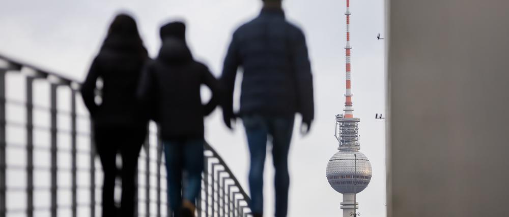 Passanten gehen vor dem Berliner Fernsehturm über den Marie-Elisabeth-Lüders-Steg.