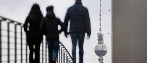 Passanten gehen vor dem Berliner Fernsehturm über den Marie-Elisabeth-Lüders-Steg.