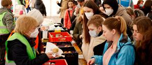 Helfer verteilen Lebensmittel an Kriegsflüchtlinge aus der Ukraine in der „Welcome Hall Land Berlin“, der ersten Anlaufstelle nach der Ankunft der Flüchtlinge auf dem Hauptbahnhof.