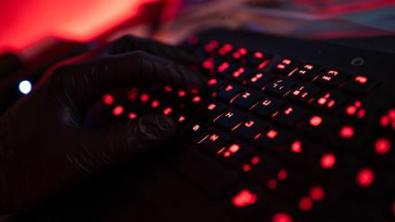 Ein Mann trägt Handschuhe und tippt auf einer Tastatur