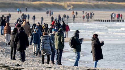 Spaziergänger sind am Ostseestrand unterwegs.