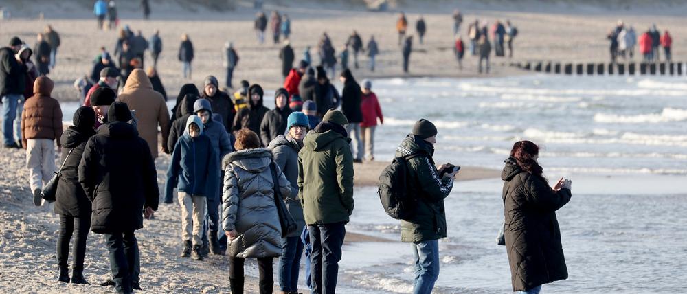 Spaziergänger sind am Ostseestrand unterwegs.