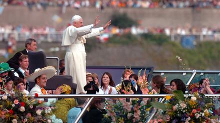 Der damalige Papst Benedikt XVI. grüßt von einem Schiff auf dem Rhein die Besucher des Weltjugendtages am Ufer in Köln. 