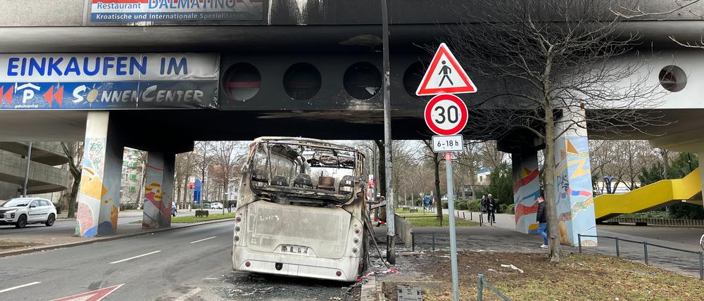 Ein ausgebrannter Bus in der Sonnenallee. Das Haus darüber wurde ebenfalls in Mitleidenschaft gezogen.