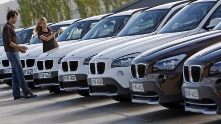 Ein junges Paar betrachtet während einer Pressevorführung einen BMW X1.