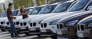 Ein junges Paar betrachtet während einer Pressevorführung einen BMW X1.