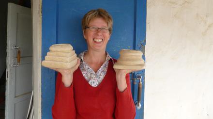 Gunvor Lindström von der Eurasien-Abteilung des Deutschen Archäologischen Instituts (DAI) am Grabungshaus in Torboluk (Tadschikistan) mit zwei baktrischen Miniaturaltären, die sie dort ausgegraben hat. 