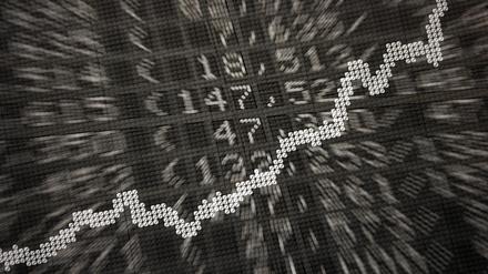 Die große Anzeige in der Börse zeigt die Dax-Kurve und verschiedene Börsenkurse.
