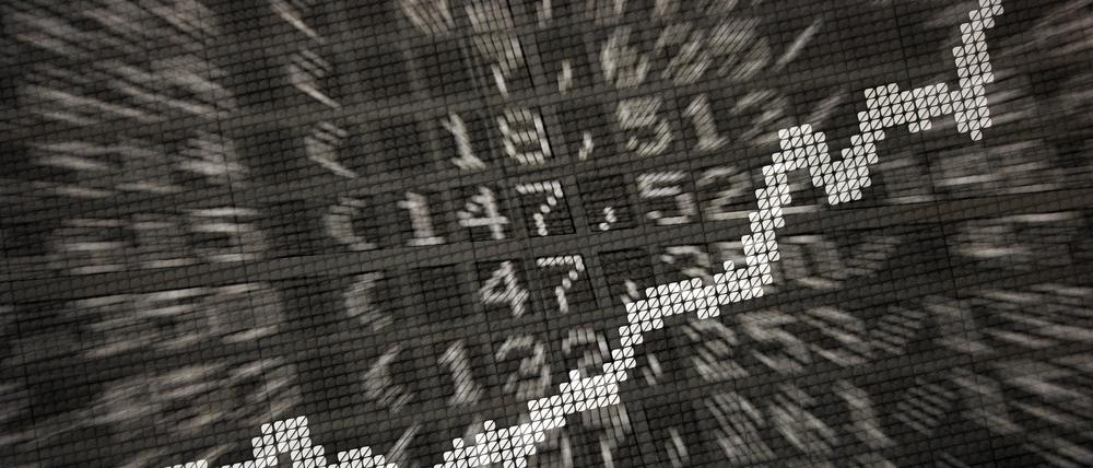 Die große Anzeige in der Börse zeigt die Dax-Kurve und verschiedene Börsenkurse.