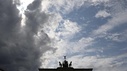 Ein graues Wolkenband zieht hinter der Silhouette der Quadriga auf dem Brandenburger Tor auf.