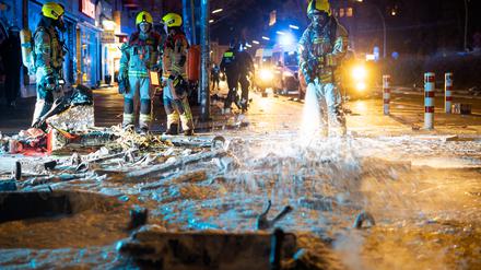 Die Reste der Randale in der Silvesternacht in Kreuzberg und Neukölln. Feuerwehrmänner löschen eine brennende Barrikade.