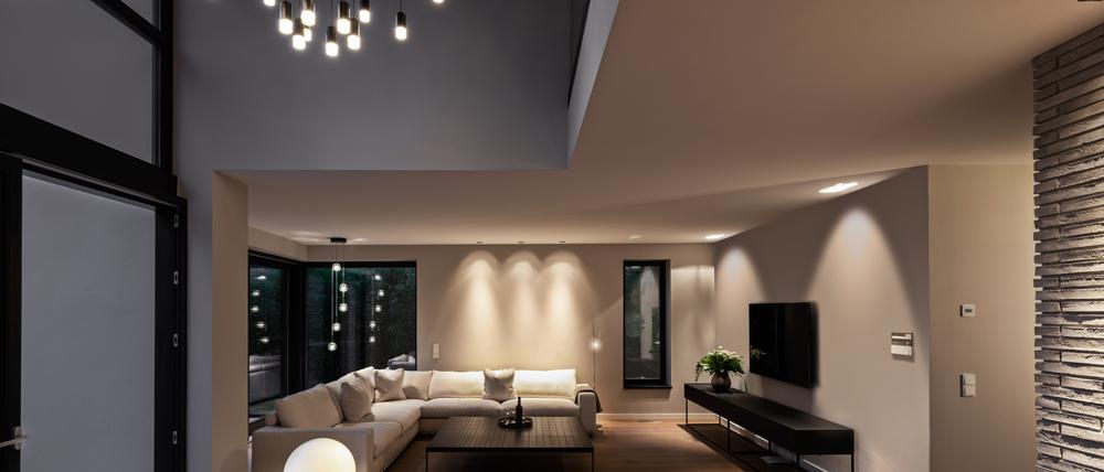 Dieses Wohnzimmer wurde mit verschiedenen Lichtquellen versehen. Die Hängeleuchte im Vordergrund ist das optische Highlight.