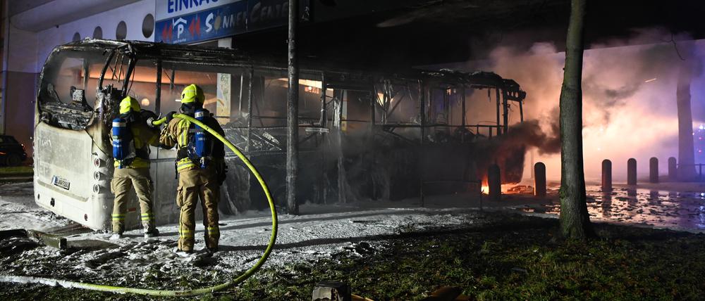 Feuerwehrmänner löschen an der Sonnenallee einen Reisebus, der in der Silvesternacht von Unbekannten angezündet worden war.