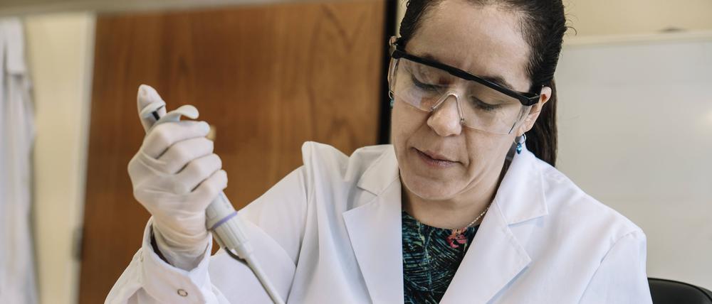 Eine Wissenschaftlerin pipettiert Proben.