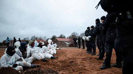 Polizisten beobachten eine Blockade durch Umweltaktivisten vor dem Braunkohletagebau in Lützerath. 