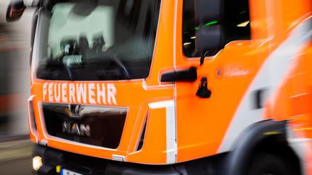 Ein Feuerwehrfahrzeug fährt aus der Wache. 