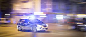 Ein Polizeiauto fährt mit Blaulicht.