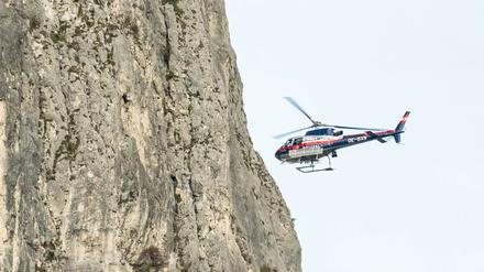 Ein Polizeihubschrauber fliegt bei Zirl nahe an einer Felswand (Symbolbild).