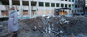 Eine Frau steht neben einem zerstörten Gebäude in Kramatorsk.