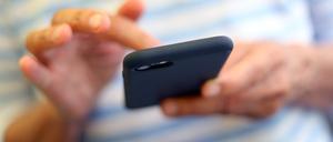 Eine Frau tippt auf einem Smartphone. 