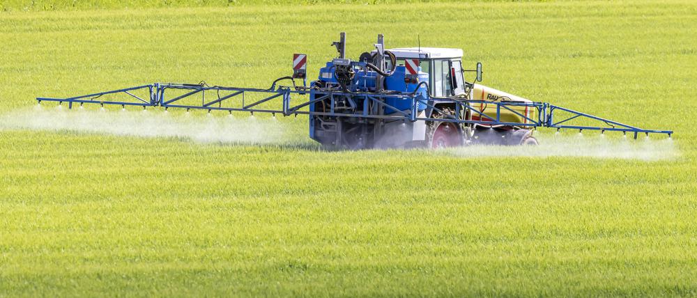 Landwirt mit Traktor düngt sein Feld (Symbolbild).