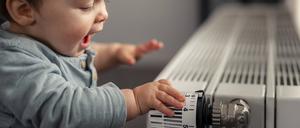 Excited baby boy playing with thermostat of heater model released Symbolfoto property released PUBLICATIONxINxGERxSUIxAUTxHUNxONLY SEBF00020  