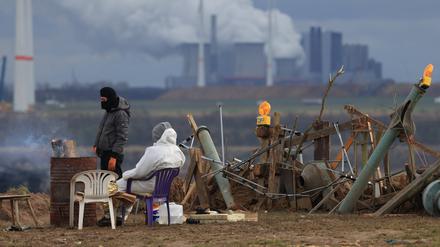 Klimaschutzaktivisten wärmen sich an einem Feuer am Rand des Tagebaus. Das Dorf Lützerath soll zur Erweiterung des Braunkohletagebaus Garzweiler II abgebaggert werden.