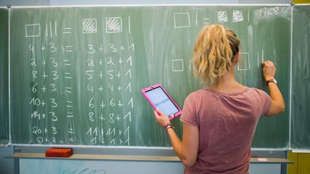 Eine Lehrerin schreibt an eine Schultafel im Mathematikunterricht.