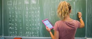 Eine Lehrerin schreibt an eine Schultafel im Mathematikunterricht.