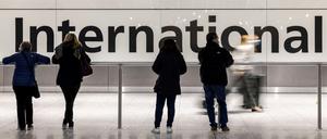 In der Ankunftshalle von London Heathrow warten Menschen.