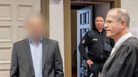 Der Angeklagte (links) steht vor der erwarteten Urteilsverkündung neben seinem Anwalt im Gerichtssaal.