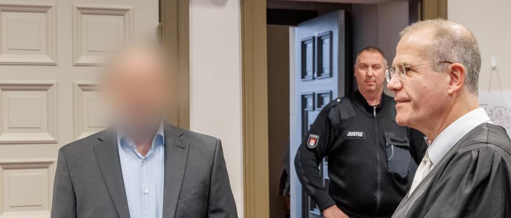 Der Angeklagte (links) steht vor der erwarteten Urteilsverkündung neben seinem Anwalt im Gerichtssaal.