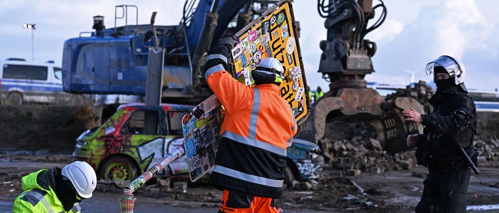 RWE-Mitarbeiter entfernen das Ortsschild des Dorfes Lützerath.
