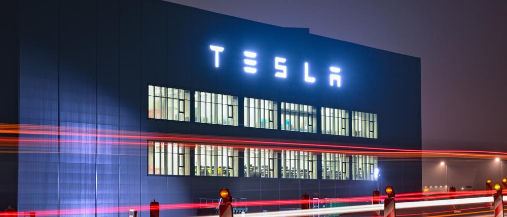 Fahrzeuge fahren am frühen Morgen auf einer Straße vor dem Gebäude der Batteriefertigung des US-Elektroautobauers Tesla vorbei.