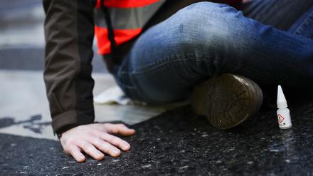 Klimaaktivistinnen und Klimaaktivisten der Organisation «Letzte Generation» kleben für eine Blockade auf eine Straße.