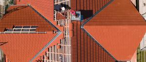 Der oder die Dachdecker installieren die Solardachziegel wie herkömmliche Ziegel. Mit einem Unterschied: Jeder muss in einen zuvor installierten Kabelbaum eingestöpselt werden.