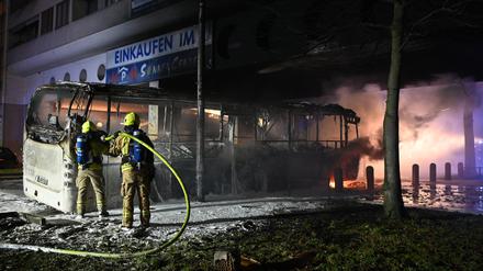 Feuerwehrleute löschen an der Sonnenallee einen Reisebus, der in der Silvesternacht von Unbekannten angezündet worden war.