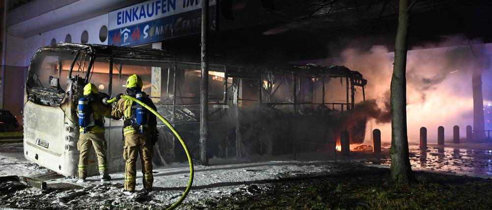Feuerwehrleute löschen an der Sonnenallee einen Reisebus, der in der Silvesternacht von Unbekannten angezündet worden war.