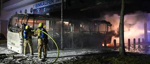 Feuerwehrleute löschen an der Sonnenallee einen Reisebus, der in der Silvesternacht von Unbekannten angezündet worden war.