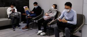 In einer Klinik in Hongkong warten Menschen auf eine Impfung.