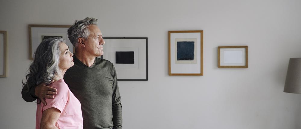 Senior couple standing in living room at home
