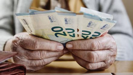 Eine Seniorin zählt ihr Geld.